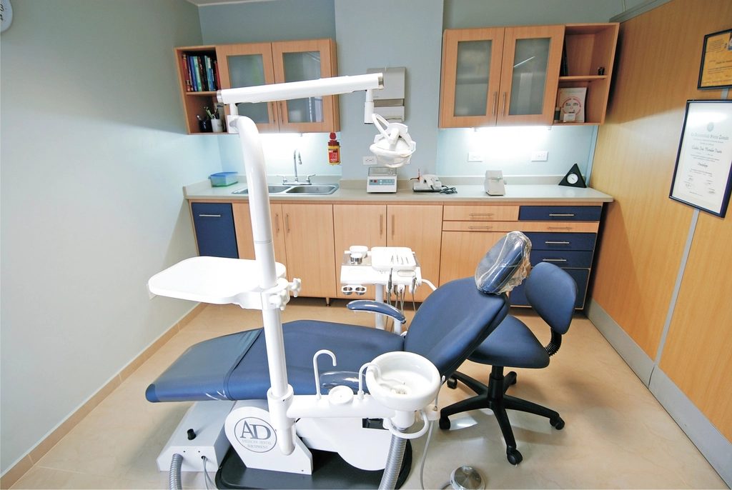 Sala de tratamiento con sillón dental y equipamiento clínico
